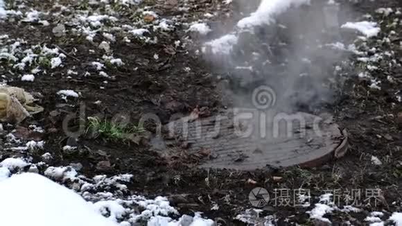 蒸汽是从卫生下水道覆盖在雪，事故。 融化的雪。 特写镜头。