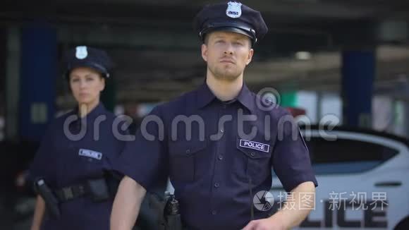 身穿制服、站在巡逻车旁的自信男女警官