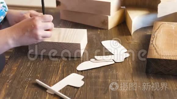 女人把纸模板重新涂到木条上。 双手特写..