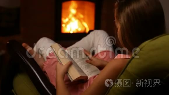小女孩坐在火炉旁的摇椅上看书视频