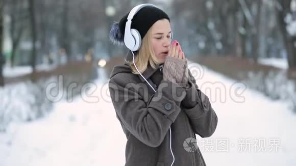 冬城的女人用耳机听音乐视频
