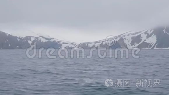 岛上雪山岭和海水冬季景观