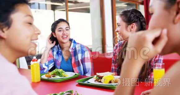 女生在吃饭时相互交流视频