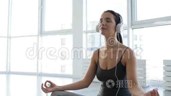靠近安静的女人，带着耳机做瑜伽