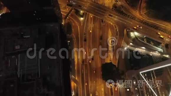 鸟瞰现代道路交叉口、建筑物和夜间行驶的汽车。股票。夜间交通道路。