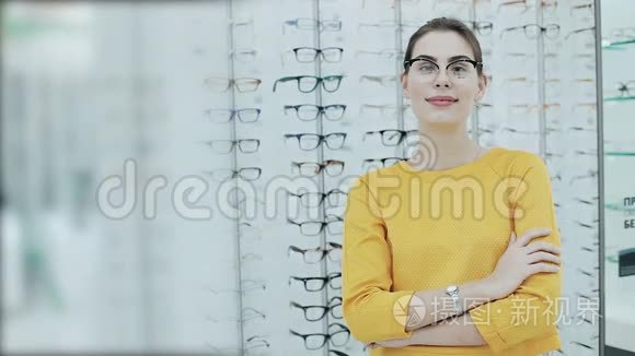 保健，视力和视力的概念.. 在光学商店戴眼镜的漂亮女人。 商店货架的背景