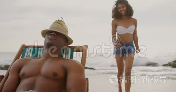 在海滩上一起玩的非裔美国人夫妇的正面景色