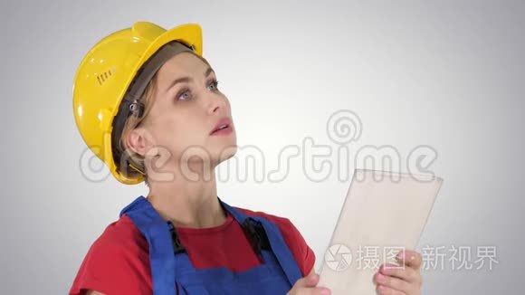 女建筑工程师与平板电脑在一个建筑工地的梯度背景。