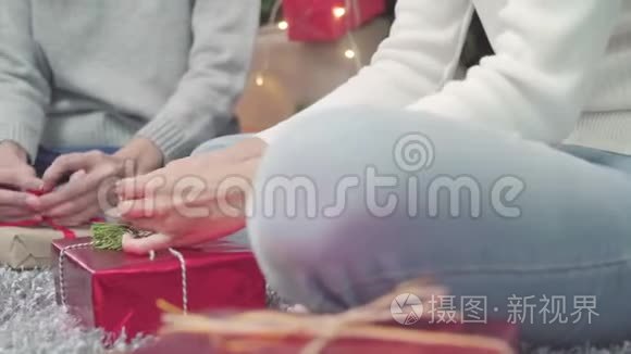 女同性恋亚洲夫妇包装和包装圣诞礼物装饰她的客厅在家里圣诞节。