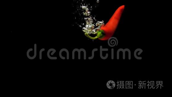 红辣椒在黑色背景下落入透明水视频