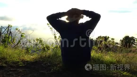 人类隐士遇见太阳升起在山的边缘。 在阳光下冥想。