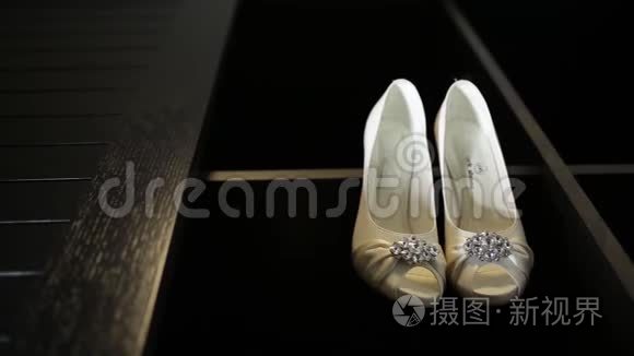 新娘婚礼漂亮的鞋子挂在一个黑色的柜子上，豪华的鞋跟特写