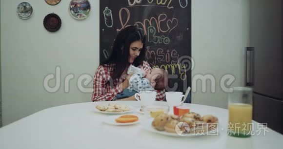 年轻的母亲在餐桌上给她的小男孩送食物