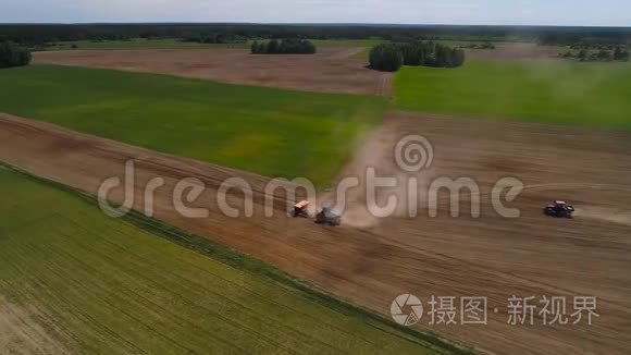 空中无人机射击两辆拖拉机播种一个领域。 一辆拖拉机停在另一辆拖拉机旁边