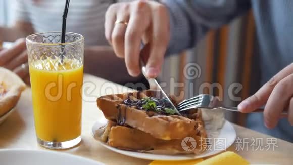 男性手用餐刀和叉子切美味的比利时华夫饼