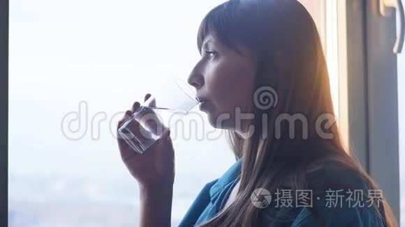 年轻女子喝着一杯水