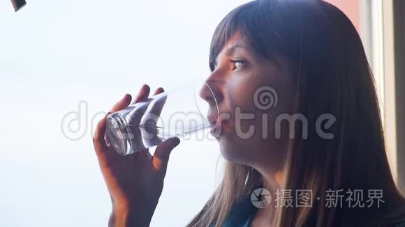 年轻女子喝着一杯水