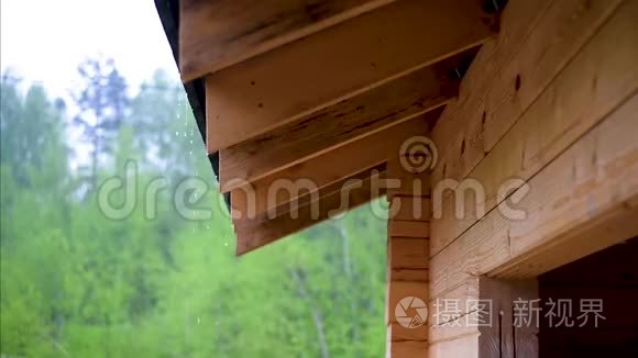 雨从一间木屋的屋顶下流下来，大雨倾盆，阴雨绵绵