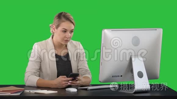 女士使用手机在办公桌上的绿色屏幕，铬键。