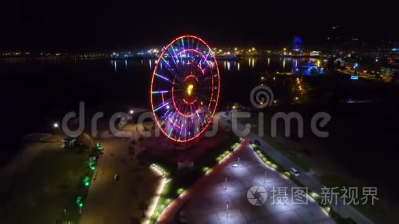 摩天轮闪烁着灯光，巴统夜景映在黑海