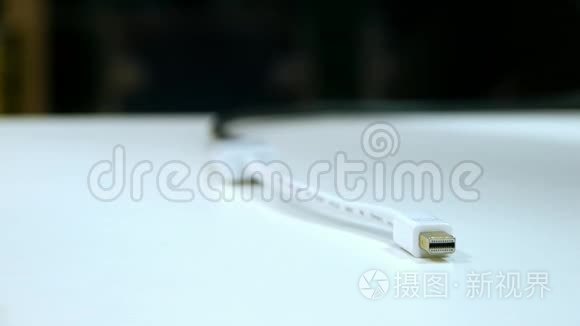 为苹果公司充电的USB电源线放在白色桌子上，充电器