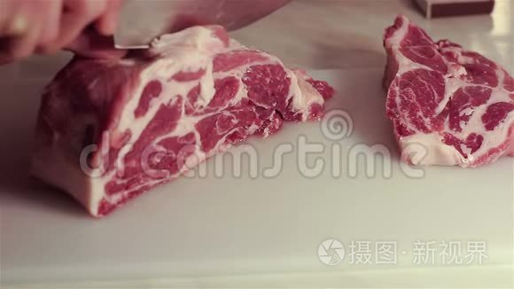 厨师把新鲜猪肉切成牛排。