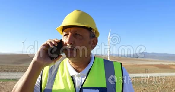 男工程师在风电场用手机通话