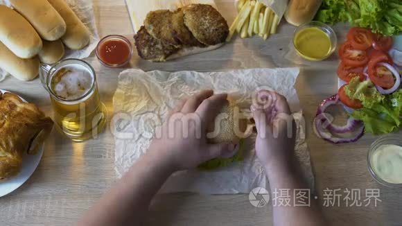 肥胖男人在他的汉堡里添加脂肪炸排，不健康的饮食，俯视图