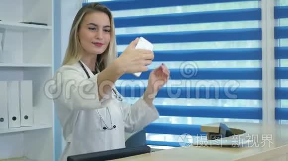微笑护士在前台拿着手机视频
