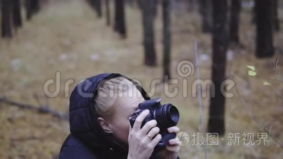 摄影师旅行者在秋天的森林里拍摄大自然的照片。 电影拍摄，慢镜头拍摄。