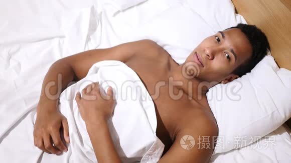 非裔美国人在床上放松，在镜头中寻找