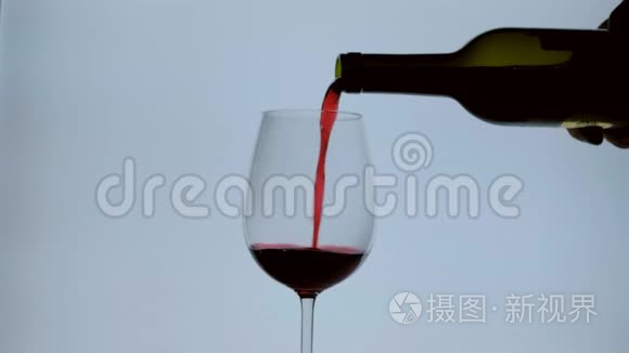 电影摄影圈。 把红酒从瓶子里倒入酒杯。