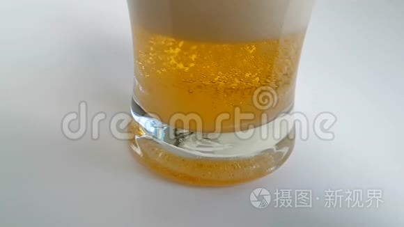 啤酒倒在白色背景上的玻璃杯里，慢镜头