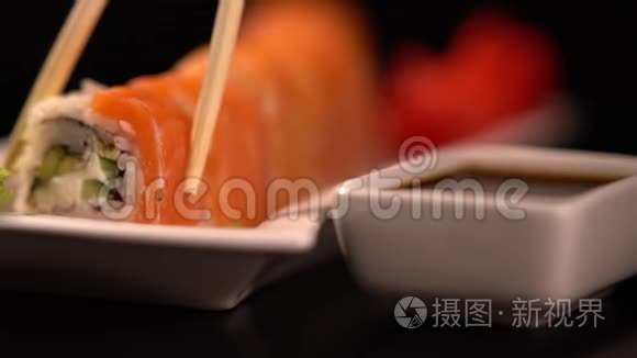 用筷子蘸酱的寿司卷