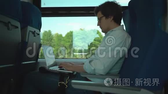 年轻商人在火车上的笔记本电脑上打字
