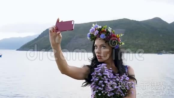 女人用海洋背景的花朵拍照视频