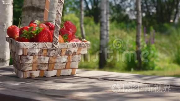 一篮子成熟的草莓落在木桌上