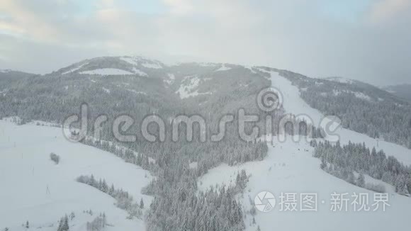 在喀尔巴阡山的滑雪场飞行。 鸟`山上白雪覆盖的房子的视野。 农村