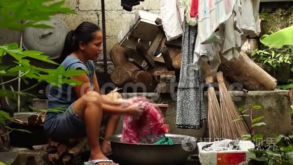 家庭主妇在不整洁的后院洗衣服
