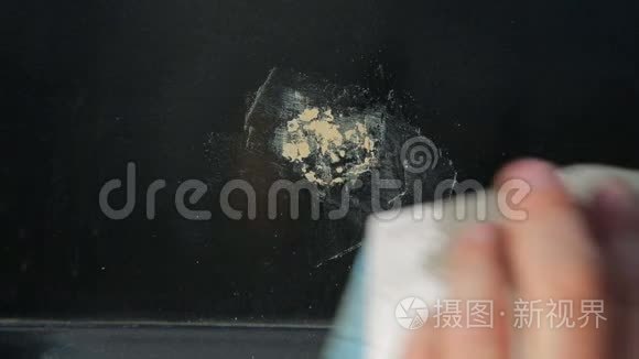 一个人用纸清洗汽车后部的铁锈。