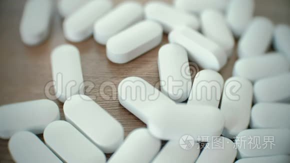 吃药片new- 00:174k白色胶囊躺在明亮的橙色药片与小蓝色止痛药.