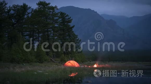 夜晚露营和池塘附近火焰的时间