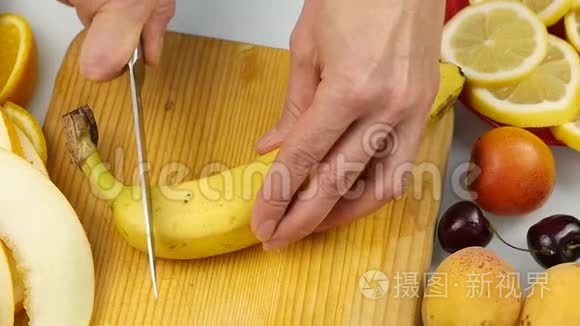 女人把香蕉片并排切在切割板上，放着香蕉片。 慢动作