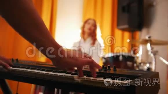 重复。 打鼓的女孩和键盘上的男人。 双手集中