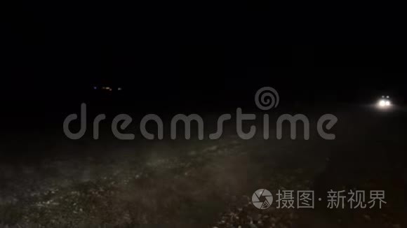 汽车在夜间暴风雪中在冬天的道路上行驶。 危险的冬季道路。 在暴风雪中开车。 提供Wi汽车