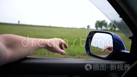 汽车在高速公路上的移动。 司机开着窗户开车。 在镜子里反射双手。 家庭成员