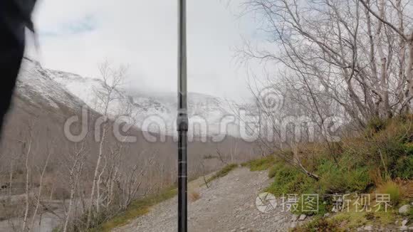 一个带着背包沿着山路行走的中年男子。 他旅行并过着健康的生活方式。