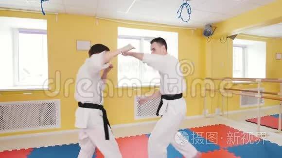 武术。 两个运动员在工作室训练他们的合气道技能。 把对手扔到地上