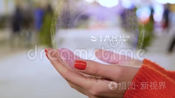 女性手拿着带有文字启动的全息图