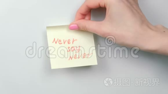 特写的女人`她的手贴着黄色的贴纸纸，上面写着永远不会说的话。